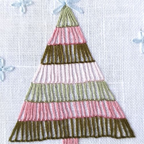रंगीन धागों और कम्बल टांकों से कढ़ाई किया गया क्रिसमस ट्री